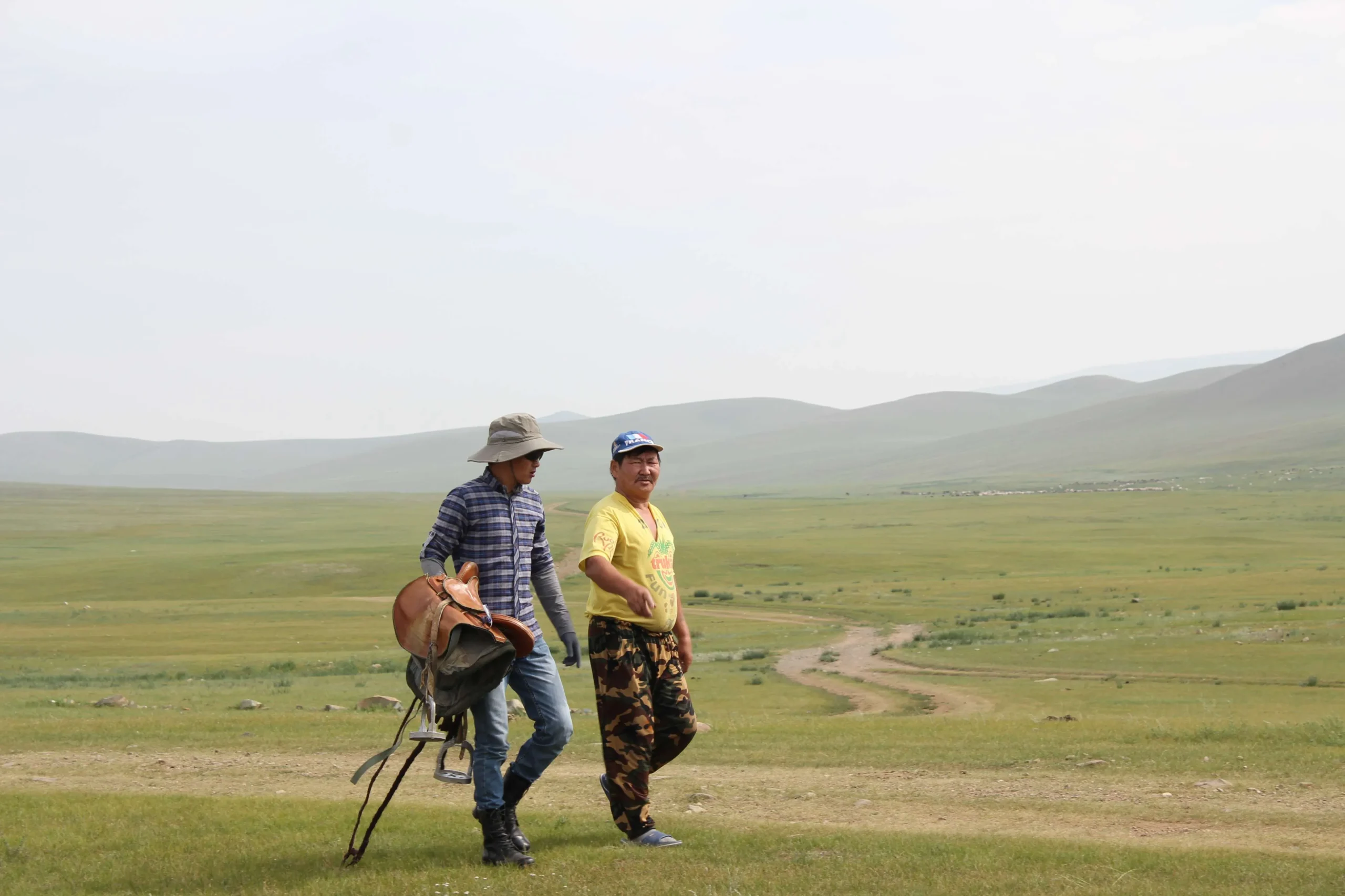 Bataa holding saddle and walking