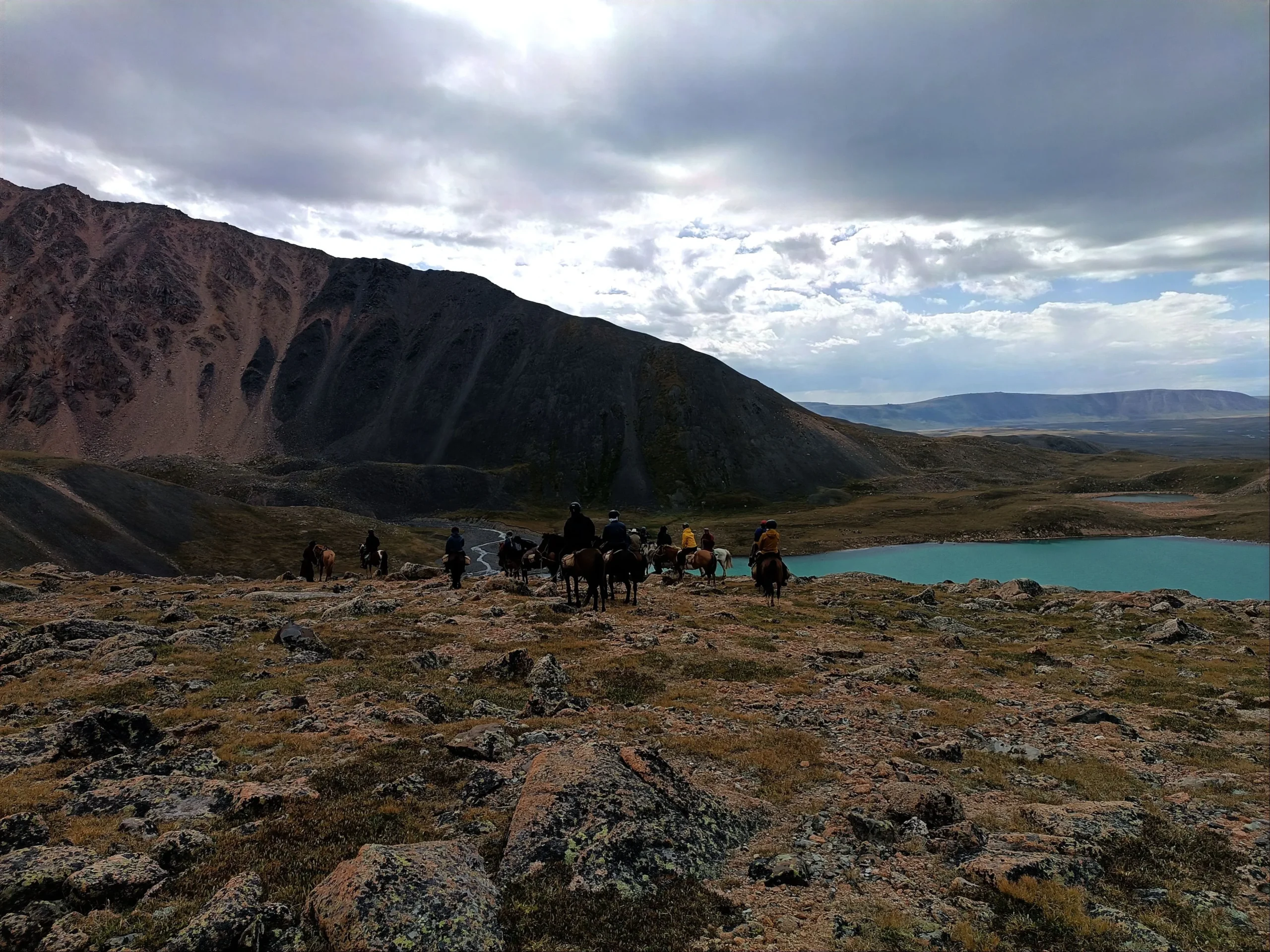 Alpine lake and Horse riders in Altai mountains