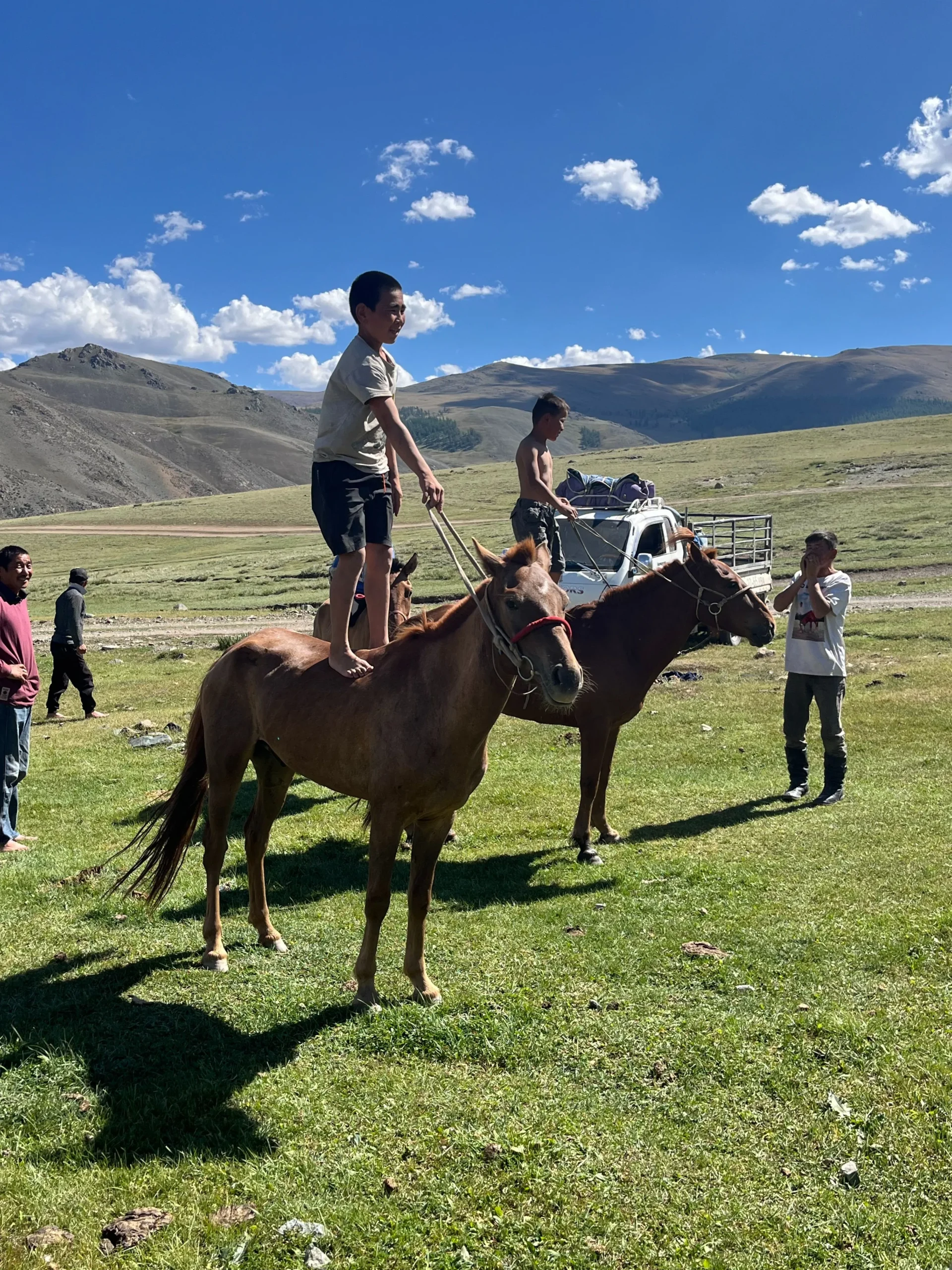 Kids standing on a horseback