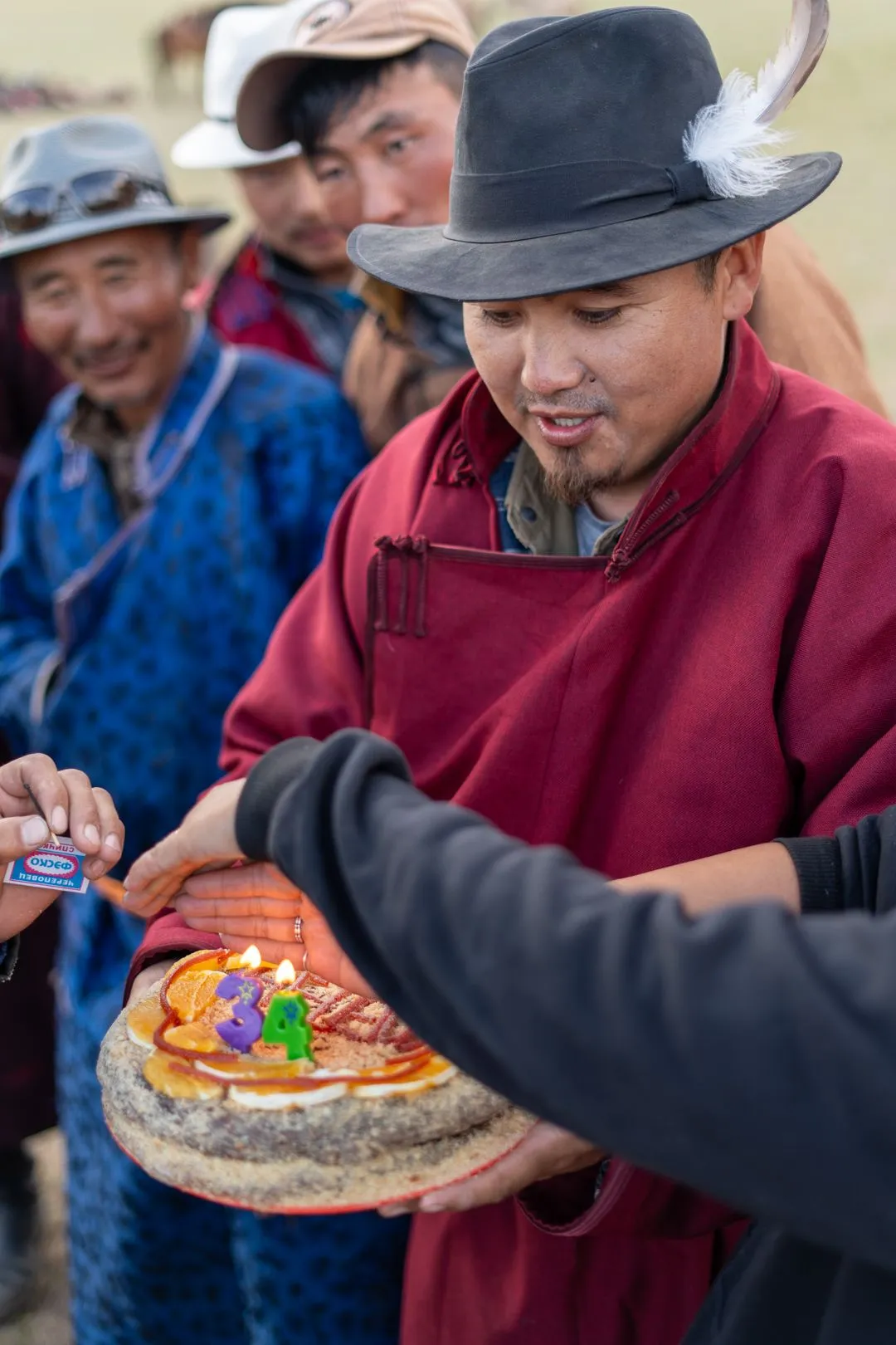Bataa, holding guest's birthday cake and others singing birthday song